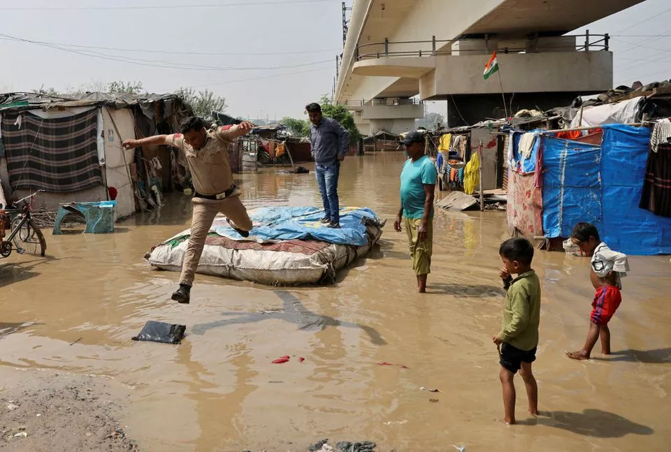 a policeman jumps off a makeshift raft after wading through a flooded area of a slum on the banks of the river yamuna in new delhi india september 28 2022 photo reuters file a policeman jumps off a makeshift raft after wading through a flooded area of a slum on the banks of the river yamuna in new delhi india september 28 2022 photo reuters file