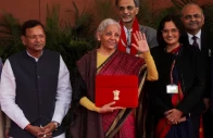 india s finance minister nirmala sitharaman waves as she holds a folder bearing the government of india s emblem while posing with her officials before leaving her office to present the annual federal budget in parliament in new delhi india february 1 photo reuters