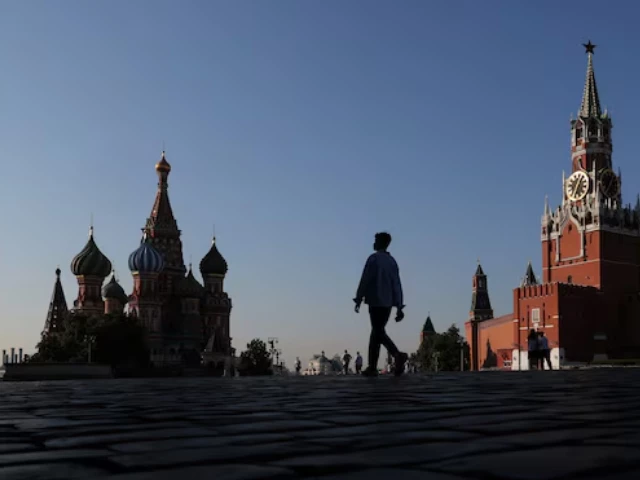 people walk in front of st basil s cathedral and spasskaya tower in red square in moscow russia july 25 2025 photo reuters