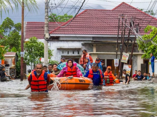 a rescue team evacuates women and children in a rubber boat as tuesday photo afp