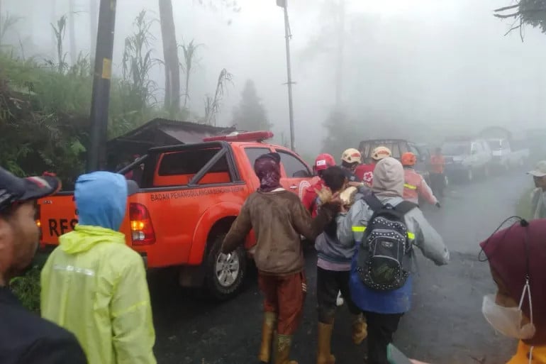 in this handout picture taken and released on january 21 2025 by indonesia s disaster mitigation agency shows rescuers and villagers evacuate victims of a landslide at kasimpar village in pekalongan central java photo afp