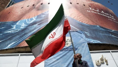 a man holds an iranian flag near an anti u s billboard depicting us president donald trump and the strait of hormuz in tehran iran may 30 2026 wana west asia news agency via reuters
