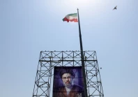 a bird flies near an iranian flag and a banner with a picture of iran s supreme leader mojtaba khamenei in tehran photo reuters