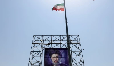 a bird flies near an iranian flag and a banner with a picture of iran s supreme leader mojtaba khamenei in tehran photo reuters
