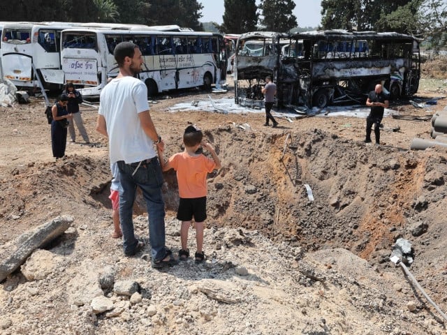Onlookers stand in front of a huge crater at the impact site of an Iranian missile at a bus depot in Herzliya near Tel Aviv on June 17, 2025. Israel's military said air raid sirens sounded in several areas of the country on June 17 after identifying missiles launched from Iran, as AFP journalists reported booms over Tel Aviv and Jerusalem. Photo: AFP