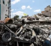 a woman holds a hezbollah flag amid rubble of destroyed buildings in deir qanoun al nahr tyre district southern lebanon june 15 2026 reuters