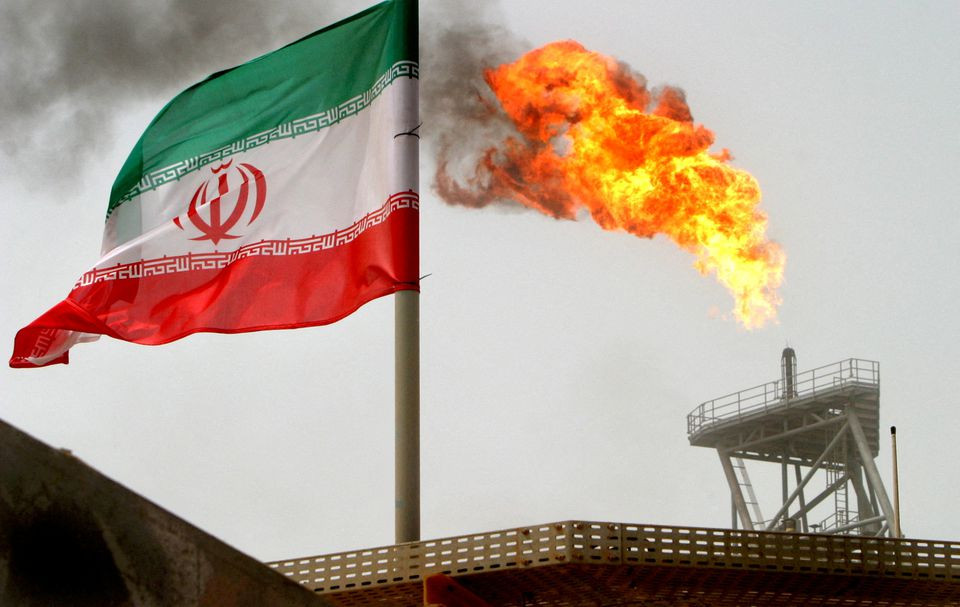 a gas flare on an oil production platform is seen alongside an iranian flag in the gulf july 25 2005 photo reuters file