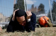 people take cover on the ground as sirens sound near the site of a fatal iranian missile strike on sunday amid the u s  israel conflict with iran in beit shemesh israel march 2 2026 photo reuters