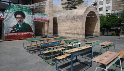 a banner with a picture of iran s new supreme leader mojtaba khamenei next to a symbolic classroom of the minab school students who were killed in a strike in tehran iran may 8 2026 photo reuters