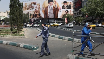 people walk past a billboard featuring images of iran s late supreme leader ayatollah ali khamenei in tehran iran july 13 2026 photo wana reuters