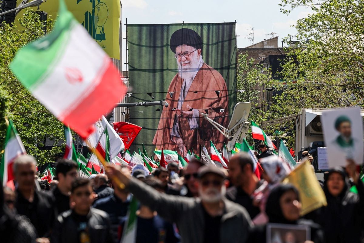 People carry a banner with an image of late Supreme Leader of Iran Ayatollah Ali Khamenei during the ceremony in Tehran. REUTERS