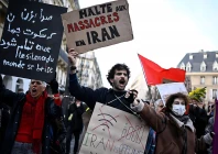 a protester holds a placard reading stop the massacres in iran during a rally in support of the iranian people in paris on january 17 2026 afp