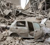 a destroyed vehicle amid rubble at the site of a strike on a residential building amid the us israeli conflict with iran in tehran iran march 16 2026 reuters