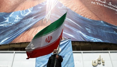 a man holds an iranian flag near an anti us billboard depicting us president donald trump and the strait of hormuz in tehran iran on may 2 2026 photo reuters