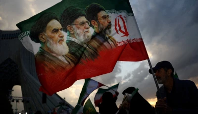 a man holds a flag with a picture of late leader of the islamic revolution ayatollah ruhollah khomeini late supreme leader of iran ayatollah ali khamenei and iran s new supreme leader mojtaba khamenei during a rally in tehran on april 29 2026 photo reuters