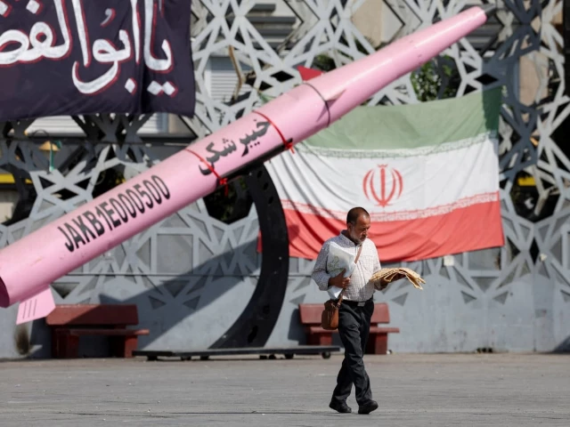 a man walks next to a symbolic mockup of an iranian missile and an iranian flag at imam hussein square in tehran iran july 12 2026 photo reuters a man walks next to a symbolic mockup of an iranian missile and an iranian flag at imam hussein square in tehran iran july 12 2026 photo reuters