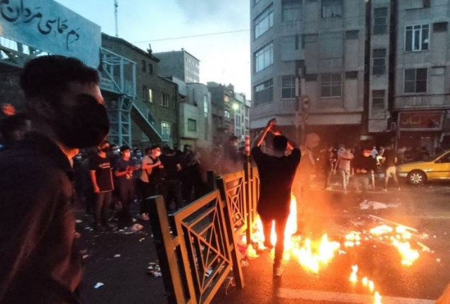 people light a fire during a protest over the death of mahsa amini a woman who died after being arrested by the islamic republic s morality police in tehran iran september 21 2022 wana west asia news agency photo reuters