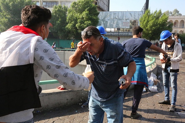 Iraqi demonstrators wash their faces to remove tear gas in the Iraqi capital Baghdad's Tahrir square on October 26, 2019 (Photo: AFP)