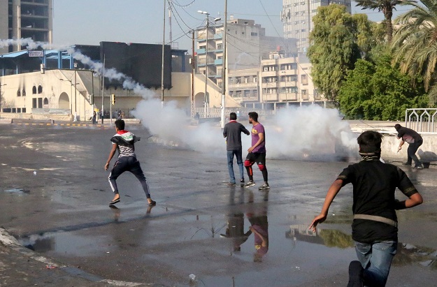 Demonstrators gather in the Iraqi capital Baghdad's Tahrir square as security forces use tear gas to push them away (Photo: AFP)