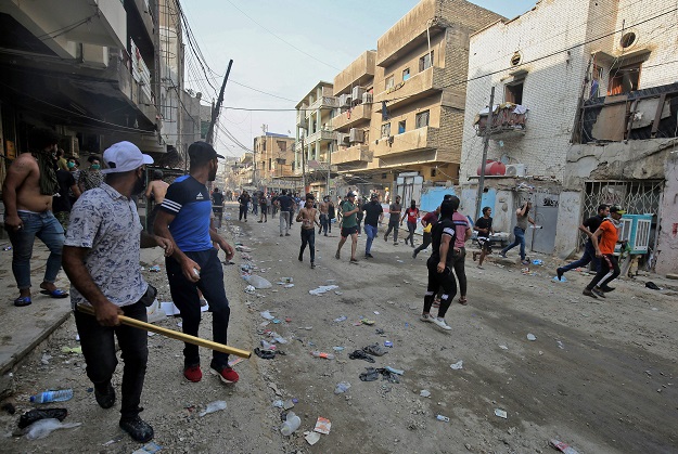 Protesters, some holding stones and others metal rods, flee from riot police firing tear gas and live rounds during clashes amidst demonstrations (Photo: AFP)