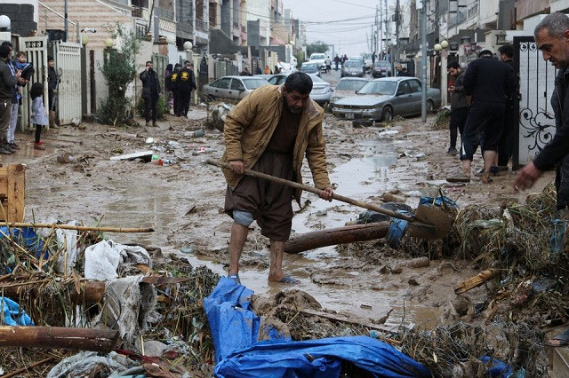 residents clean a road full of mud after flash floods caused by torrential rains in erbil iraq december 17 2021 reuters azad lashkari