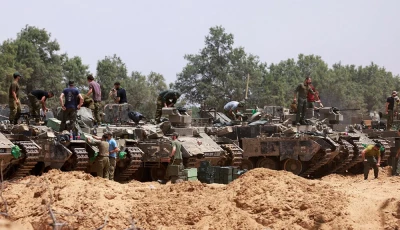 israeli troops work on their armoured vehicles at a position by israel s border with the gaza strip on may 18 2025 photo afp