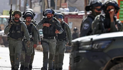 members of israeli security forces patrol along a street during a military raid in the neighbourhood of kafr aqab near ramallah in the israeli occupied west bank on january 26 2026 photo afp