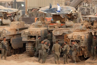 israeli army soldiers gather near infantry fighting vehicles ifvs at a position along the israel gaza border fence on october 10 2025 gaza s civil defence agency said october 10 that israeli forces have begun pulling back from parts of the territory particularly in gaza city and khan yunis photo afp