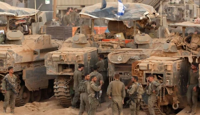 israeli army soldiers gather near infantry fighting vehicles ifvs at a position along the israel gaza border fence on october 10 2025 gaza s civil defence agency said october 10 that israeli forces have begun pulling back from parts of the territory particularly in gaza city and khan yunis photo afp