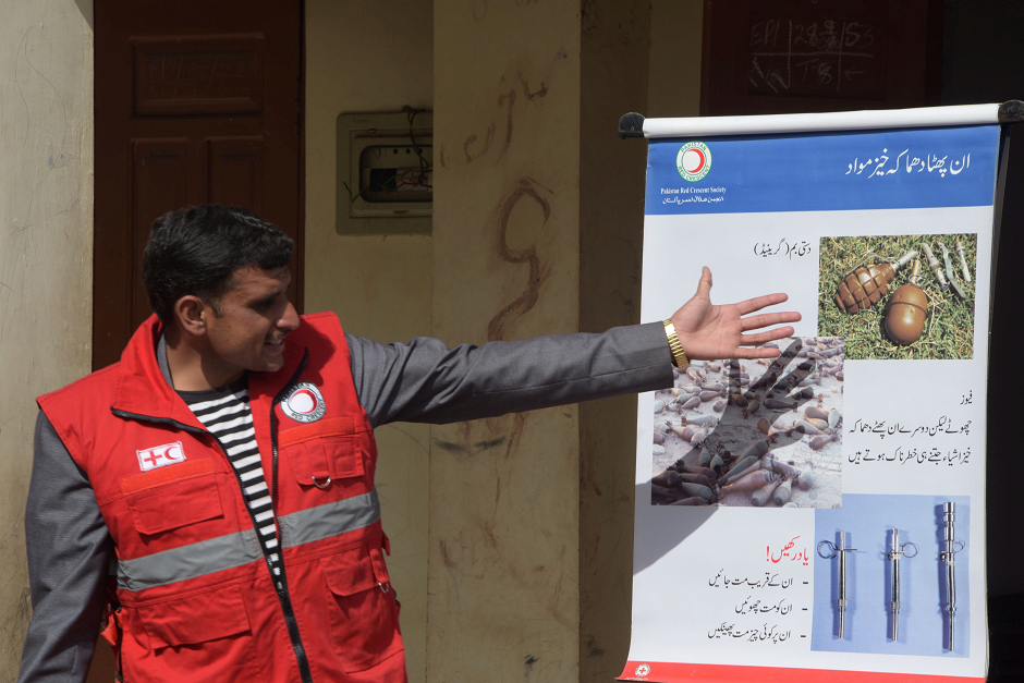 An official of the Pakistan Red Crescent Society (PRCS) leading an awareness campaign for landmines to local residents in Abbaspur Sector. PHOTO: AFP.