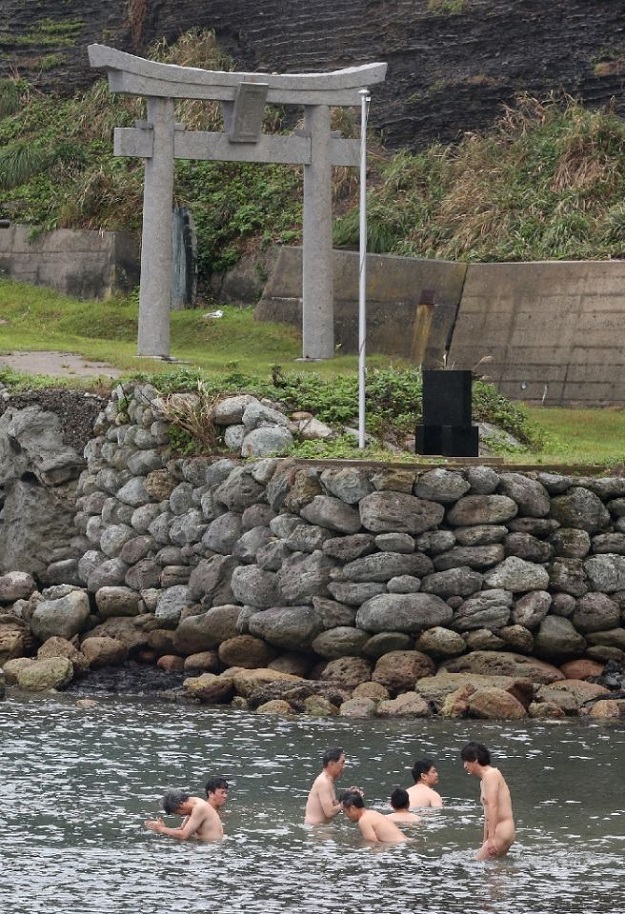 Devotees purify themselves with sea water before entering Okinoshima island in Japan. PHOTO: AFP