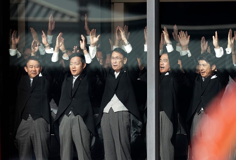 Japanese officials shout banzai cheers for Emperor Naruhito (top L) and Empress Masako during the enthronement ceremony. PHOTO: AFP