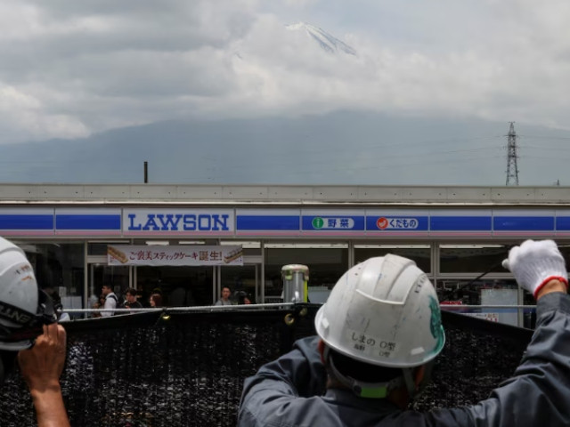 workers erect a barrier to block the view of a popular mount fuji photo spot near a convenience store in fujikawaguchiko town yamanashi prefecture japan may 21 2024 photo reuters