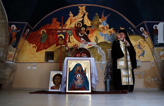 Archbishop Joseph Jules Zerey (C) of the Melkite Greek Catholic Church blesses foreign students of the Bethlehem Icon Center as they present the works executed during their course, in the biblical West Bank city of Bethlehem on April 11, 2017. PHOTO: AFP