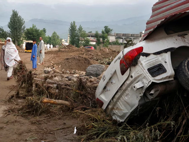 a woman walks past a damaged vehicle following heavy rain and floods in buner district in khyber pakhtunkhwa province pakistan august 16 2025 photo reuters