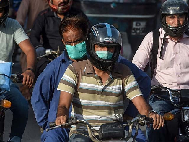 motorists wearing facemasks on a busy street in karachi photo afp