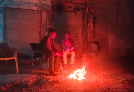 as the night s chill sets in men gather around a fire seeking warmth and comfort the flickering flames offer not just heat but a brief moment of togetherness in the cold hours photo express