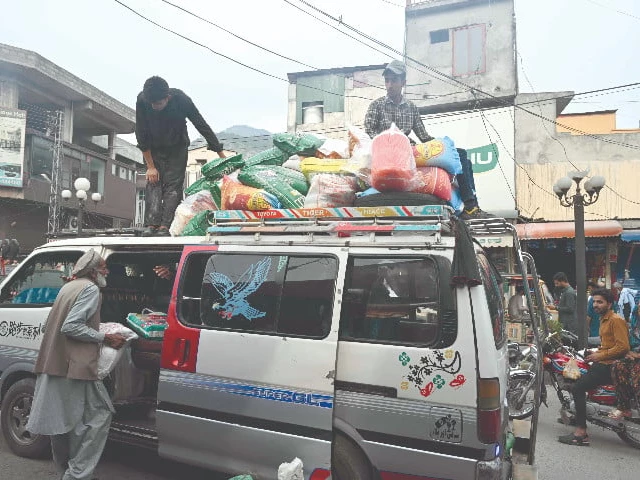an elderly man loads wheat flour bags onto a van at a market in muzaffarabad photo afp an elderly man loads wheat flour bags onto a van at a market in muzaffarabad photo afp