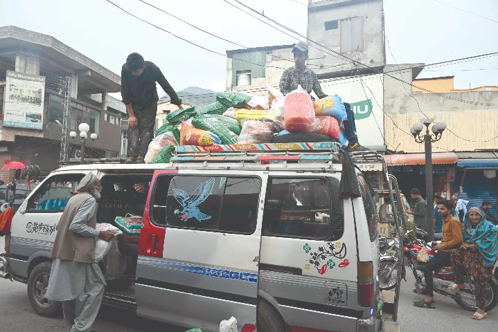 an elderly man loads wheat flour bags onto a van at a market in muzaffarabad photo afp an elderly man loads wheat flour bags onto a van at a market in muzaffarabad photo afp