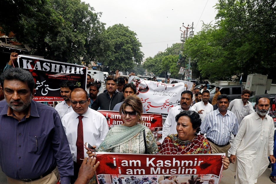 Demonstrators hold signs and chant slogans as they march in solidarity with the people of Kashmir, during a rally in KarachI. PHOTO: REUTERS