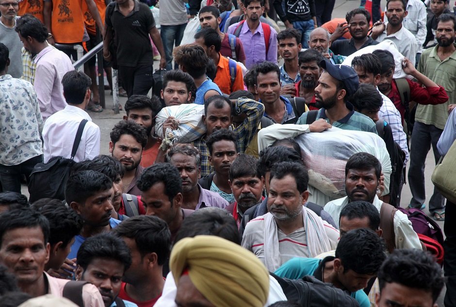 Labourers from across India working in Kashmir wait outside Jammu Railway Station as they leave to go back to their home states due to the heightened security situation in Jammu. PHOTO: AFP