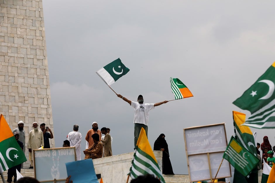 A man waves Pakistan's and Azad Kashmir's flags during a countrywide 'Kashmir Hour' to express solidarity with the people of Kashmir. PHOTO: Reuters