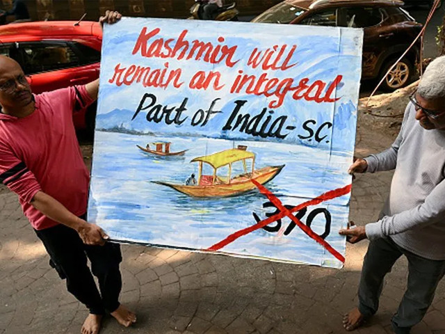 a teacher in mumbai carries a painting depicting the supreme court s verdict on kashmir photo afp