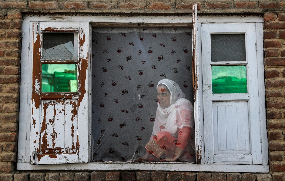 A Kashmiri woman watches protests in Anchar neighbourhood. PHOTO: REUTERS