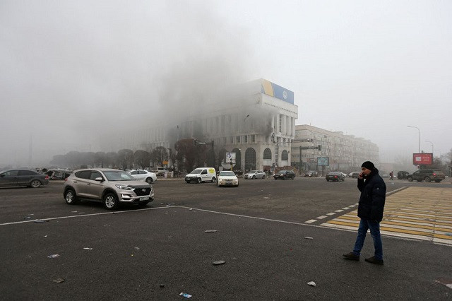 a man stands near the building of the kazakhstan state tv channel which was torched during protests triggered by fuel price increase in almaty kazakhstan january 6 2022 reuters pavel mikheyev