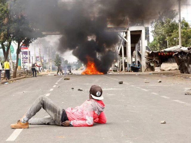 a demonstrator lies on the road watching clashes with police as a fire burns at the saba saba people s march anti government protest in nairobi kenya july 7 photo reuters a demonstrator lies on the road watching clashes with police as a fire burns at the saba saba people s march anti government protest in nairobi kenya july 7 photo reuters