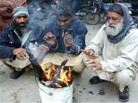 people warming their hands in karachi photo app