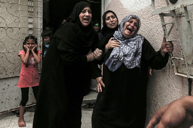 Palestinians and relatives mourn over the death of 15-year-old protester Othman Rami Halles during his funeral east of Gaza City on July 14, 2018.  PHOTO: AFP