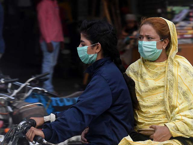women wearing facemasks ride on a motorbike in karachi photo afp women wearing facemasks ride on a motorbike in karachi photo afp