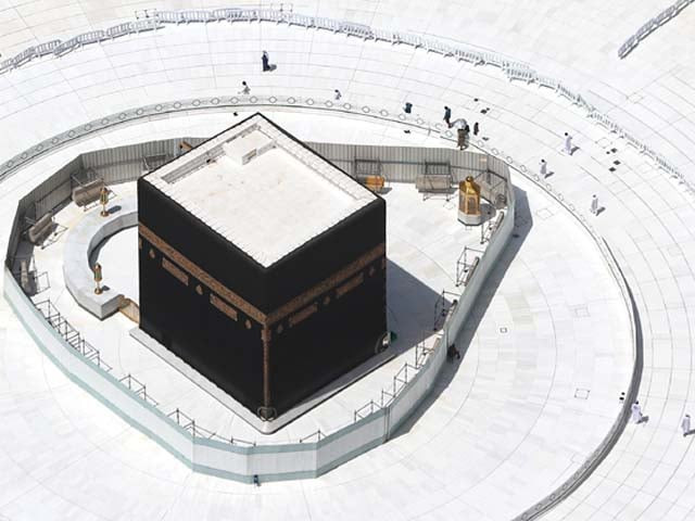 a few workers are seen nearby an empty kaaba as precautions against covid 19 are taken in mecca photo afp